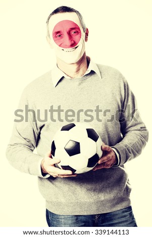 Mature man with Japan flag painted on face.
