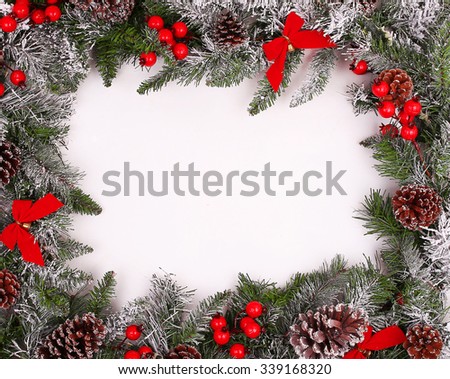 Border, frame from christmas tree branches with pine cones and holly berries 