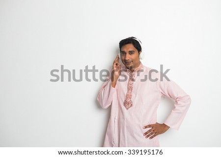 indian male enjoying music in traditional wear

