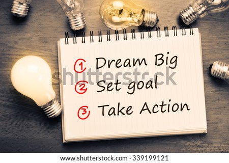 Dream Big - Set Goal - Take Action, handwriting on notebook with light bulbs Royalty-Free Stock Photo #339199121