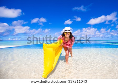 Young happy woman relaxing with air mattress during tropical vacation