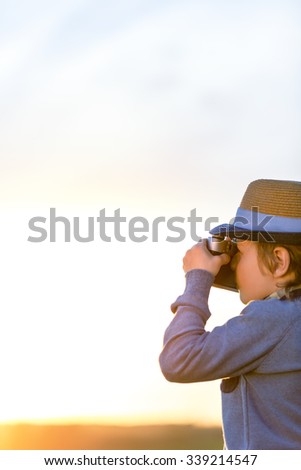 Little boy with a camera outdoors