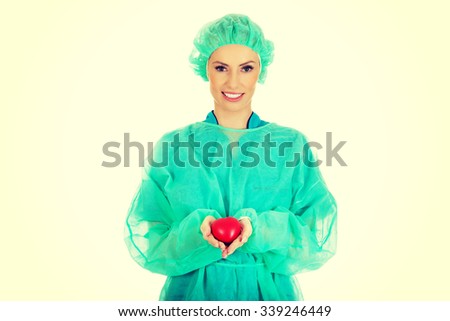 Smiling female surgeon doctor with heart.