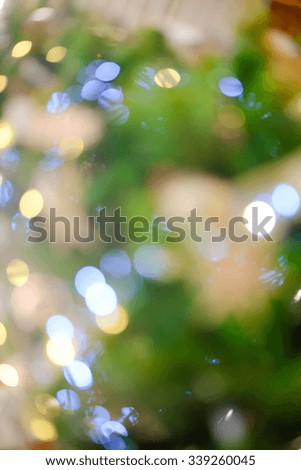 Picture of beautiful christmas tree blurred background with blue and yellow bokeh. Artistic effect background for festive decor.
