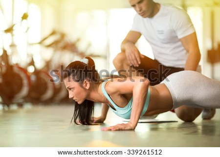 
Personal trainer working with his client in gym Royalty-Free Stock Photo #339261512