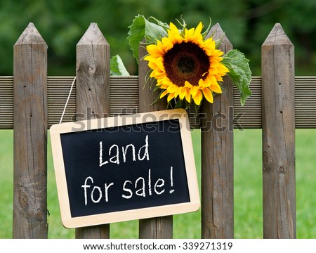 Land for sale - chalkboard with text and sunflower