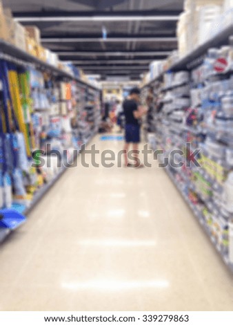 Blur man selecting the goods on shelf in the supermarket