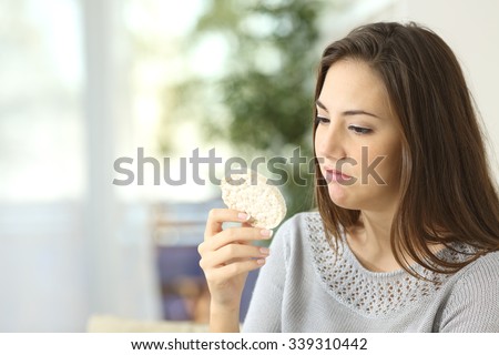 Girl disgusted looking a dietetic cookie. Bad diet concept Royalty-Free Stock Photo #339310442