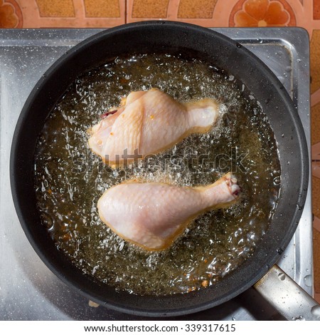 Chicken frying in a pan,Top view. Royalty-Free Stock Photo #339317615