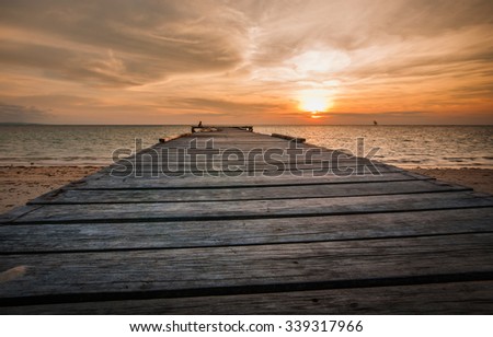 wooden jetty under the orange sunset