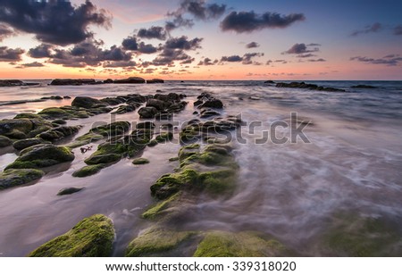 green moss rocks with cloudy sunset sky
