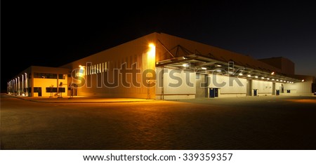 wide angle view of a modern warehouse at night in flood light light Royalty-Free Stock Photo #339359357