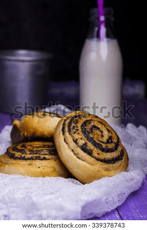 Buns with poppy seeds and a bottle of milk