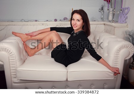full-length portrait of beautiful young  woman on couch  