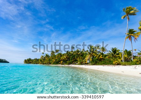 Stunning tropical Aitutaki One Foot island with palm trees, white sand, turquoise ocean water and blue sky at Cook Islands, South Pacific Royalty-Free Stock Photo #339410597