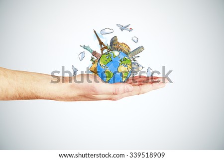 Travel concept with man hand and round earth with landmarks