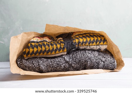 Shopping - warm sweaters in a paper bag on a wooden table