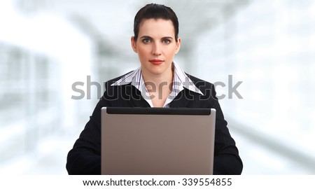 Beautiful young business woman over office background.