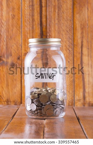 money in the glass with wooden background