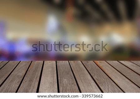 Wooden table and blurred image of motor show,show room,motor expo for background