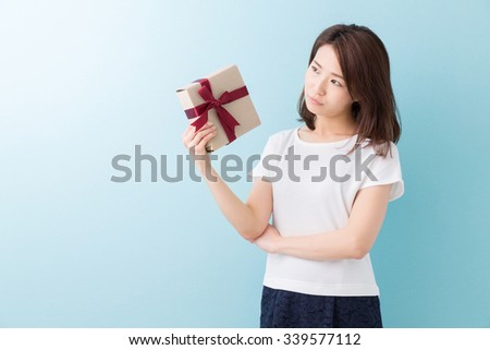 young attractive asian woman who thinks while having a present