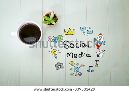 Social Media concept with a cup of coffee on a pastel green wooden table