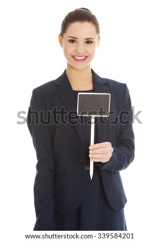 Smiling young businesswoman showing blank signboard