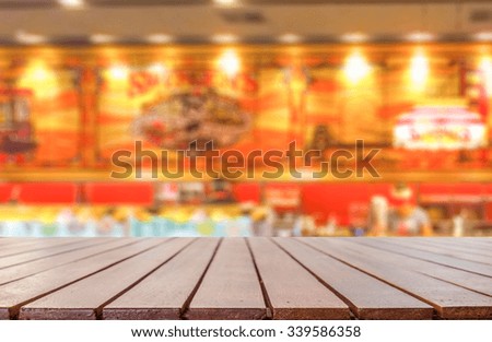 Empty wooden table platform with blurred cafe restaurant  background for presentation product.