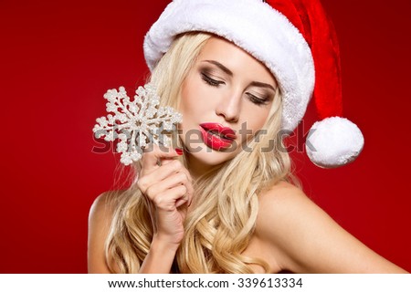 christmas, x-mas, winter, happiness concept - smiling woman in santa helper hat with many gift boxes. picture of cheerful santa helper girl with snowflake