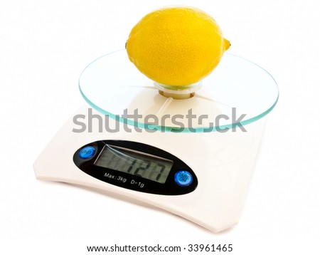 photo of the lemon at electronic scales against the white background