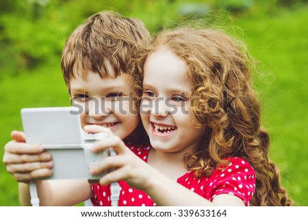 Children taking selfie with photo camera.