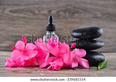 Essence oil and flower with zen stone on wood background