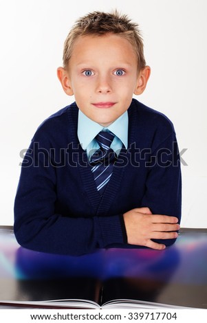 Cute little boy is looking at pictures in a book, isolated over white background
