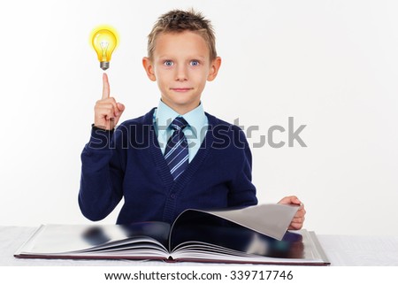 Cute little serious preschooler boy with a raised finger is wearing official clothes, isolated over white background