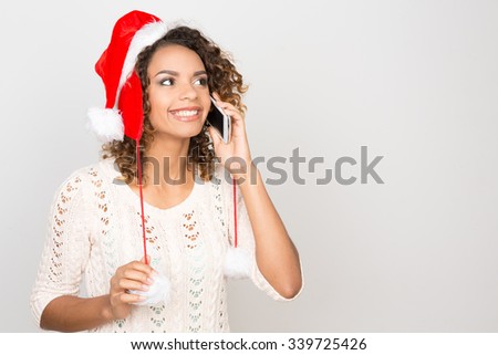 Calling family on Christmas. Half length portrait of a cheerful African woman talking on the phone and smiling