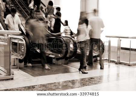 Abstract photo of people moving on escalator in the shopping mall(signs on escalator - bowling, karaoke)