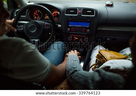 Couple Driving inside the car Along with holding hands. Royalty-Free Stock Photo #339764123
