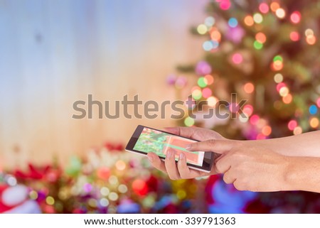 concept idea background image of hand using phone with ornaments in Christmas time .