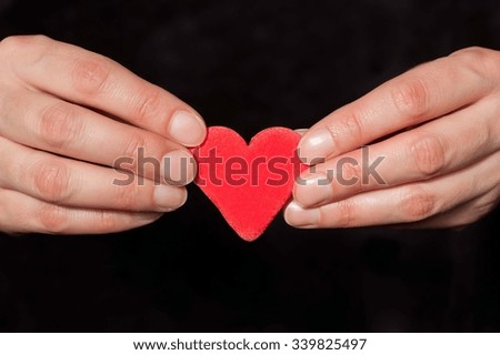 fingers hold a heart of clay