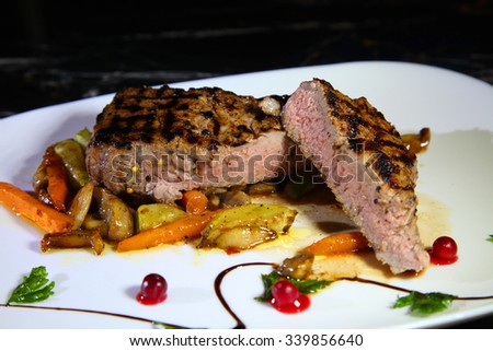 Beef steak medium rare on vegetable cushion. Beef steak on a white plate - Stock Image
