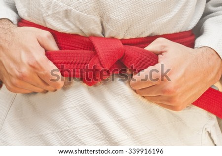 Aikido red belt on white kimono Royalty-Free Stock Photo #339916196