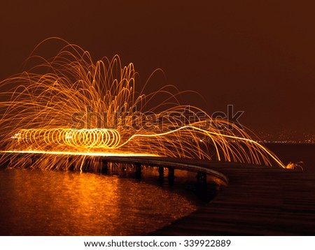 Steel Wool and light painting on wooden pier at beach