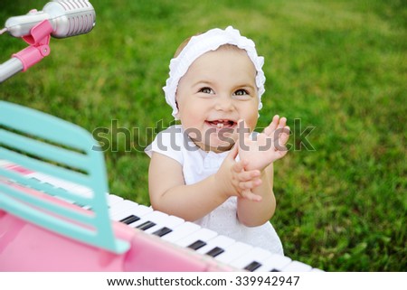 Child little girl playing on a toy piano
