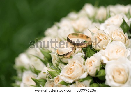Closeup view of one beautiful fresh bright white yellow big wedding bouquet of rose flowers lying on green grass sunny day outdoor on natural background, horizonbtal picture