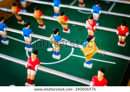 old table soccer with red and blue players fixed with adhesive tape, selective focus.