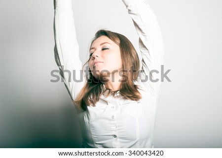 Business woman stretches after a long sitting at the table. studio photo on a gray background