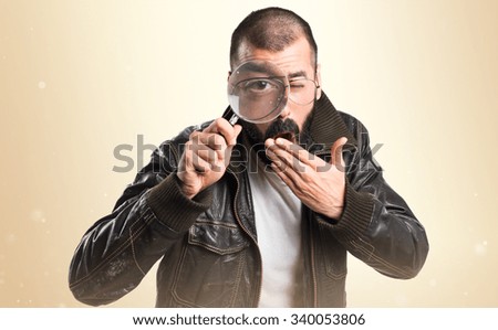 Man wearing a leather jacket with magnifying glass