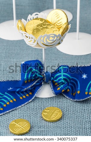Close up of chocolate Hanukkah gelt coins in vase with Hanukkah bow.
