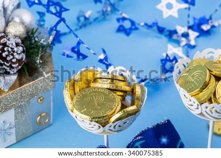 Close up of chocolate Hanukkah gelt coins in vases and gift box.