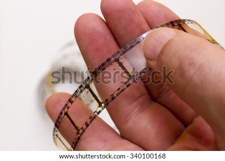 Old film strip in the man's hand as a symbol of cinema.